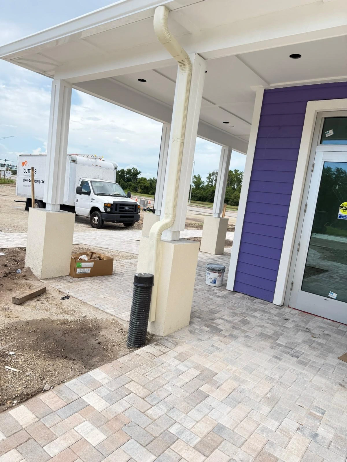 White soffit and downspout along a covered entrance